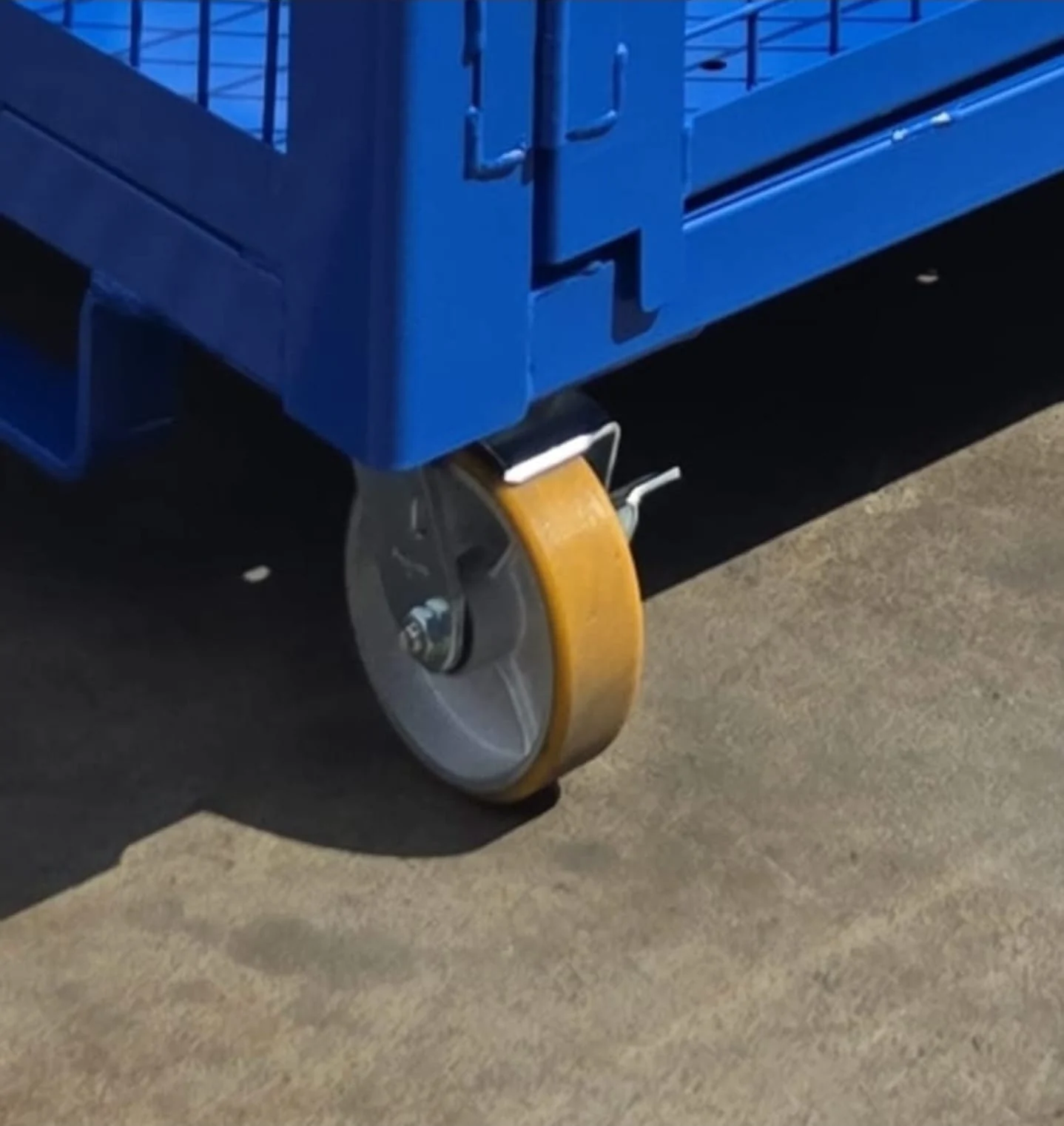 Caster wheel fitted to a blue coated industrial rack