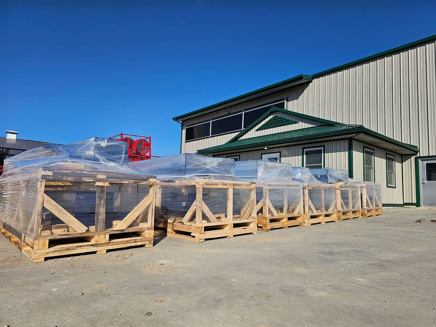Wrapped industrial assemblies in wooden shipping crates outside the facility