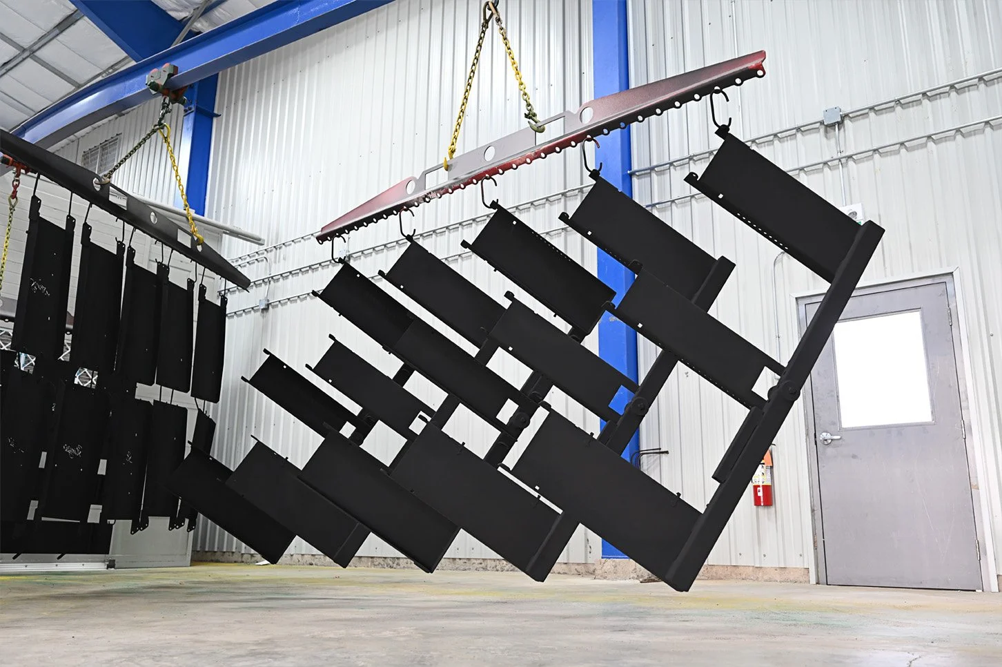 Black steel frames suspended from an overhead rail