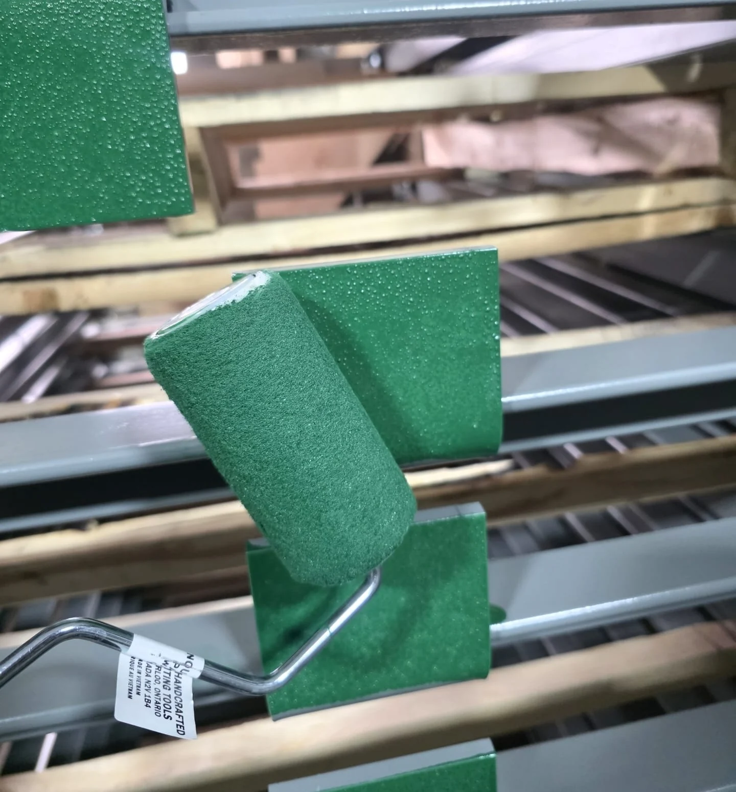 Green paint roller shown as an example of assembly after painting