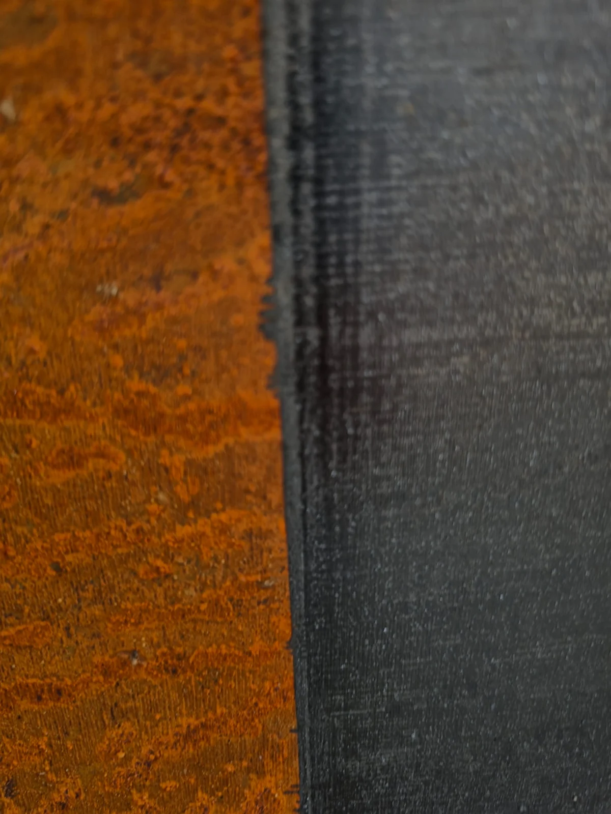 Close-up showing rusted steel beside a cleaned metal surface