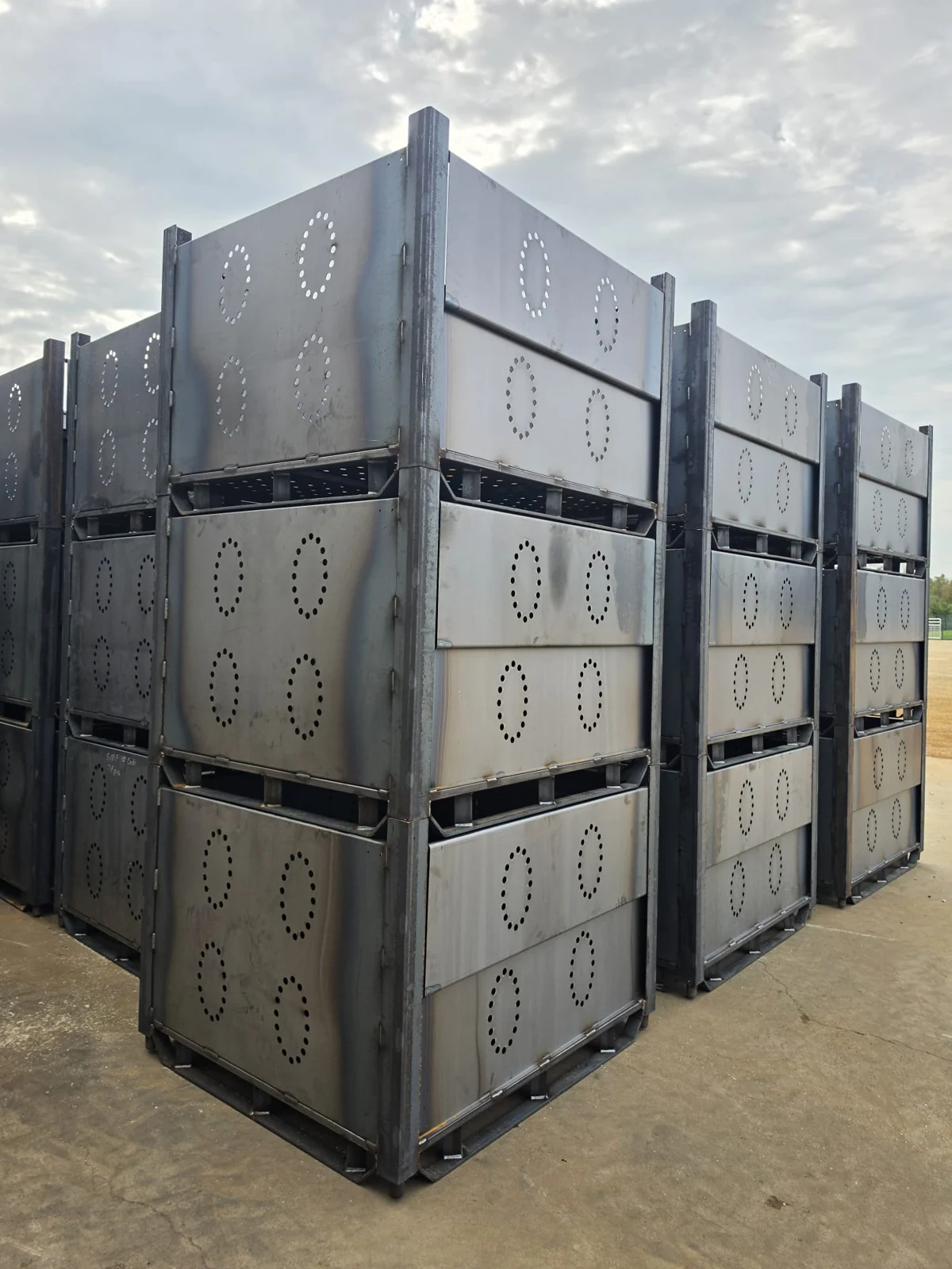 Uncoated industrial enclosures stacked outside